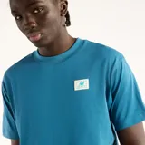 Remera New Balance de corte regular fit y cuello redondo, color azul con pequeño parche tejido en el pecho.