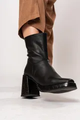 Bota de caña media color negro, de cuero, con horma cuadrada, taco geométrico con textura símil cocodrilo y plataforma.