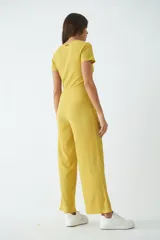 Monoprenda larga de textura acanalada, color mostaza, con escote en V cruzado y mangas cortas.