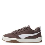 Championes Puma de estilo urbano inspirados en el skate, con perfil bajo. Presentan una estructura combinada de material sintético y superposiciones de gamuza en color negro, con el icónico logo de la marca en blanco en el lateral. Cuentan con cordones gruesos en color crema, entresuela blanca y suela de goma color caramelo.