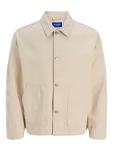 Camisa de denim color beige claro, corte amplio, cuello clásico, cierre frontal con botones y mangas largas. Confeccionada en tejido denim de sarga con acabado acid wash.