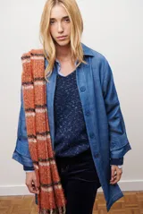 Spolverino largo de jean color azul, con cuello camisero, botones frontales y costuras decorativas en blanco.