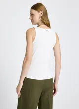 Musculosa blanca de punto con escote redondo, tirantes anchos y detalle de botones decorativos en el frente.
