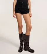 Short de jean negro con cintura alta, corte slim, trabillas en la cintura, cierre tradicional, bolsillos y rayas de strass con brillos laterales.