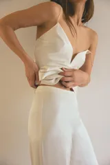 Pantalón de tiro alto con pernera recta, confeccionado en tejido satinado de viscosa. Presenta un cierre lateral con cremallera oculta en la costura.