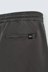 Pantalón tipo jogger de corte slim fit, confeccionado en tejido de algodón con elasticidad. Presenta cintura elástica ajustable con cordón, bolsillos frontales, bolsillos traseros de vivo y bajos con puños elásticos.