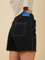 Short de corte holgado con costuras en contraste color blanco. Presenta bolsillos tipo cargo en el frente y ruedo deshilachado.