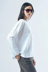 Remera de manga larga con corte oversize, confeccionada en algodón de color blanco, con cuello redondo y diseño minimalista.