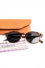 Lentes de sol polarizados con armazón redondo de carey marrón y micas oscuras.
