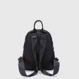 Mochila urbana de diseño compacto, color negro, con compartimento principal y bolsillo frontal con cierre. Presenta el logo de la marca grabado en relieve en la parte inferior y asa superior de mano.