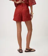 Short corto de crochet Marfinno color rojo, con diseño calado, bordado abstracto integral, aplicación de lentejuelas, pretina con pasadores y cierre delantero. Cuenta con forro interior.