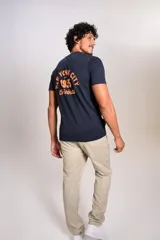 Remera de cuello redondo y manga corta en color azul marino, con estampado pequeño en el pecho que incluye el texto New York City 1955 Original en color naranja.