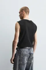 Musculosa blanca de algodón con cuello redondo y sisas amplias.