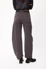 Jean de corte wide leg y diseño tipo balloon, color gris oscuro con efecto lavado. Presenta cintura alta con pasacintos, bolsillos traseros clásicos y costuras laterales reforzadas que acentúan su silueta voluminosa.