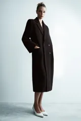 Abrigo oversize de Zara Woman Collection confeccionado en hilatura con lana. Presenta cuello con solapa de muescas, manga larga, bolsillos con solapa en el delantero y cierre frontal cruzado con botones.