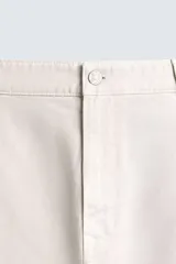 Pantalón cargo de corte recto confeccionado en tejido de algodón. Presenta bolsillos laterales con solapa en las perneras, bolsillos frontales y bolsillos traseros de vivo. Cuenta con cierre frontal de cremallera y botón.