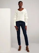 Pantalón de jean azul oscuro de corte recto, con tiro alto, cinco bolsillos y cierre frontal con cremallera y botón.