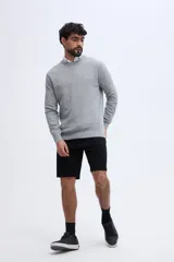 Sweater gris claro de punto, con cuello redondo, manga larga y calce clásico. Presenta un pequeño bordado en el pecho.