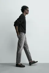 Pantalón de jean corte slim fit, color gris con efecto lavado. Presenta diseño de cinco bolsillos, cierre frontal con cremallera y botón, y tejido elástico.