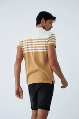 Remera tipo polo de manga corta con diseño a rayas horizontales en color blanco y tostado. Presenta cuello clásico, cierre frontal con botones y logo pequeño bordado en el pecho.