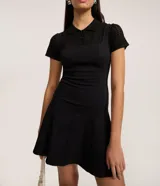 Vestido corto negro de corte evasé, con escote cuadrado y breteles anchos. Presenta costuras verticales en el frente y la espalda para definir la silueta.