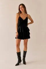 Minifalda negra de terciopelo con diseño de múltiples volantes en capas y pretina con elástico en la parte trasera.
