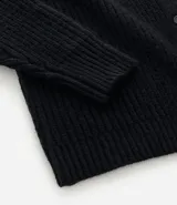 Cardigan de punto negro con textura acanalada, cierre frontal con botones, cuello redondo y mangas largas con puños ajustados.