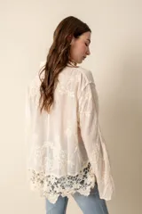 Camisa color crema con bordados florales, de corte holgado y mangas largas.