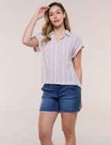 Camisa de lino de estructura recta, color beige con rayas verticales blancas. Cuenta con cuello solapa, escote en V abierto, abotonadura frontal, bolsillo plaqué en el pecho, mangas cortas de hombro caído y ruedo recto.