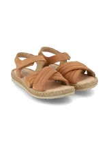Sandalia de cuero nobuck color camel, con tiras cruzadas en el empeine, tira ajustable con cierre de velcro en el tobillo y suela de PVC ultraflexible.