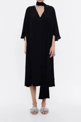 Vestido midi negro de viscosa fluida con escote en V, mangas 3/4 con vuelo, canesú fruncido en la espalda y lazos extralargos para cruzar en el cuello.