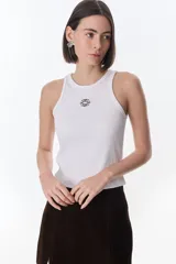 Musculosa marrón de tejido rib elástico con cuello redondo, diseño sin mangas y detalle de bordado decorativo en el centro del pecho.