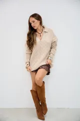 Sweater de punto trenzado color beige, con cuello en V y cuello polo, de manga larga y corte holgado.