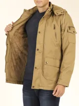 Campera de abrigo estilo parka, color verde militar, con capucha desmontable, cierre frontal con botones y múltiples bolsillos funcionales en pecho, cintura y manga.