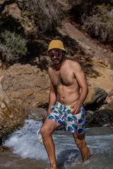 Short de baño con estampado tropical de hojas y elementos lineales sobre fondo blanco. Cuenta con cintura elástica, dos bolsillos laterales, un bolsillo trasero con etiqueta de la marca Von Braun y red interior.