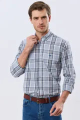 Camisa de manga larga de calce slim, con diseño a cuadros en tonos azul oscuro, verde y blanco. Presenta cuello camisero con botones y bolsillo ojal en el pecho con detalle bordado.
