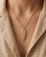 Collar de bronce con cadena fina dorada y un dije colgante en forma de espiga decorado con circonias blancas.