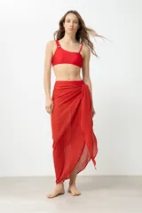 Pareo largo de color rojo, confeccionado en tela liviana con textura arrugada, ideal para usar sobre trajes de baño.