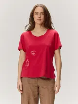 Remera roja de manga corta y cuello redondo, con detalle de bordado decorativo en el frente.