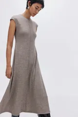 Vestido midi de punto con escote redondo, mangas japonesas y falda con leve vuelo. Presenta costuras verticales decorativas en el frente y la espalda.