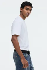 Remera blanca de manga corta, confeccionada en punto liviano con cuello redondo ribeteado y bajo recto, de corte estándar y silueta clásica.