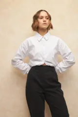 Pantalón de vestir color crema, de corte recto, con bolsillos laterales y traseros. Se ajusta a la cintura con dos botones.