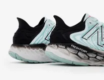 Championes de running New Balance modelo 1080 para dama, color celeste con detalles en blanco y negro.