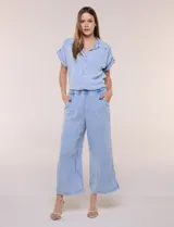 Pantalón crop de textura tramada tipo denim lavado, de calce limpio y caída fluida, con cintura elástica, bolsillos laterales y silueta ancha y recta.