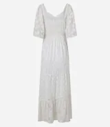 Vestido largo evasé de crepé blanco con textura y volados. Tiene escote corazón, elástico en la cintura, lazo con cordón y borla en las puntas, y mangas cortas.