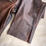 Pantalón de cuero vacuno negro, de tiro alto y corte recto con aberturas laterales en los bajos.