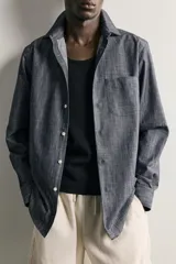 Camisa de corte regular fit confeccionada en tejido de algodón, con cuello solapa, manga larga con puños abotonados, bolsillo plastrón en el pecho y cierre frontal de botones.