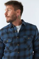 Sobrecamisa de viyela a cuadros rojos y azules con interior capitoneado, corte regular, manga larga, cierre con botones, bolsillos frontales y logo en grifa de cuero.