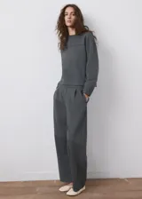 Buzo gris oscuro de piqué, de cuello redondo y manga larga con puños ajustados, con detalle de costura horizontal en el pecho.