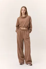 Buzo cropped de cuello alto con cordón regulable, mangas largas con puños elásticos y cintura ajustable con cordón. Presenta un diseño moderno y versátil con acabado suave.
